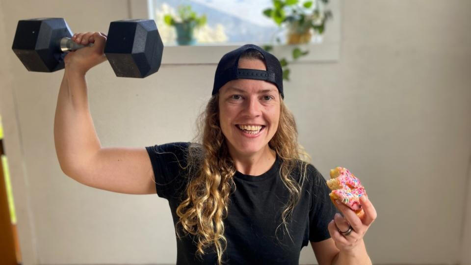 Read my interview with Sophia here Lesbian gym trainer Sophia Walker holds a dumbbell and pink donut