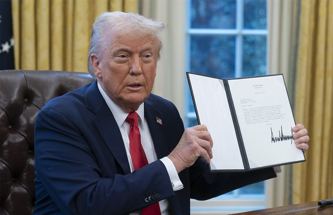 President Trump holding executive order in oval office
